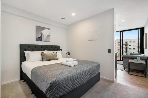 a bedroom with a large bed in a room at Beautiful Designed Auckland CBD Studio Apartment - Pool Sauna Gym in Auckland