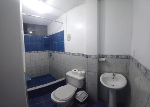 a blue and white bathroom with a toilet and a sink at Blessed Family in Lima