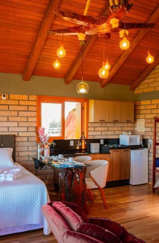 Un dormitorio con una cama y una cocina con una mesa. en Chalé Cordilheira Dos Canyons-1, en Praia Grande