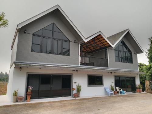 a large white house with black windows at Living in Ping in Ban Tha Kham Mae Pae