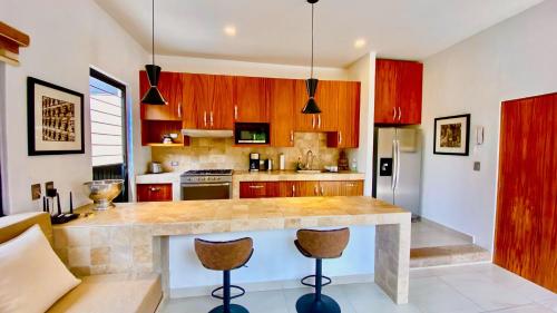 a kitchen with a large counter with two stools at Ajijic 1 Bedroom Guesthouse -Walk To Everything -Patio -Bikes - Pickleball Court in Ajijic