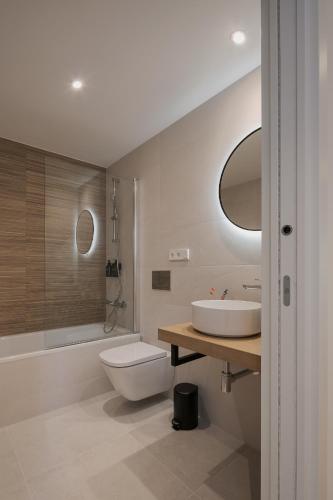 a bathroom with a sink and a toilet and a shower at Avós Apartamentos in Monforte de Lemos