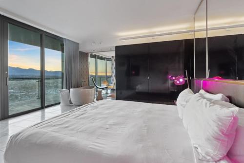 a bedroom with a large white bed with a view at The Celine Riviera Suite at Palms Place in Las Vegas