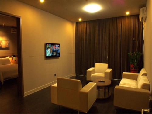 a room with two chairs and a couch and a tv at Jinjiang Inn Xiamen Jimei University Guomao in Xiamen