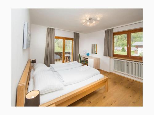 a bedroom with a large bed with white sheets at Holiday home Landhaus Prielau in Maishofen