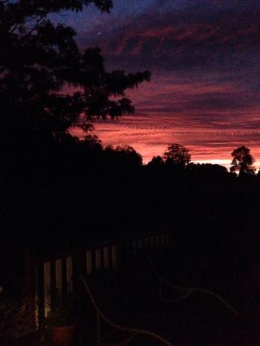 a sunset with a tree and the sky at Oma’s Kitchen at Creegans Cottage in Barkers Vale