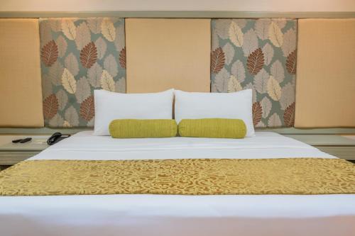 a large bed with two pillows on top of it at La Piazza Hotel and Convention Center Inc. in Legazpi