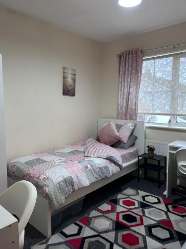a small bedroom with a bed and a window at FEMALES Only in Lucan