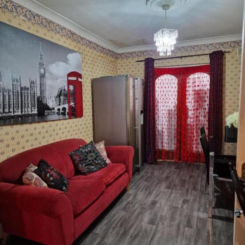 a living room with a red couch and a red phone booth at FEMALES Only in Lucan