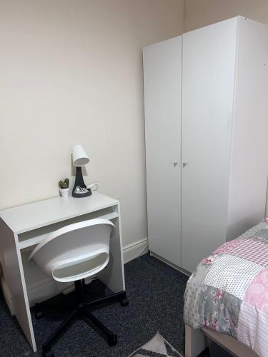 a bedroom with a white desk and a bed at FEMALES Only in Lucan