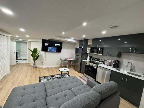 a living room with a couch and a kitchen at DJoshuas place in Edmonton