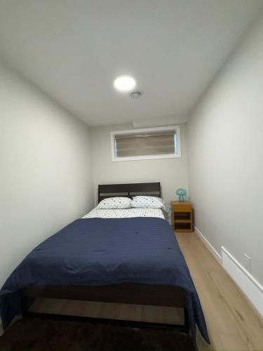 a bedroom with a bed with a blue blanket at DJoshuas place in Edmonton