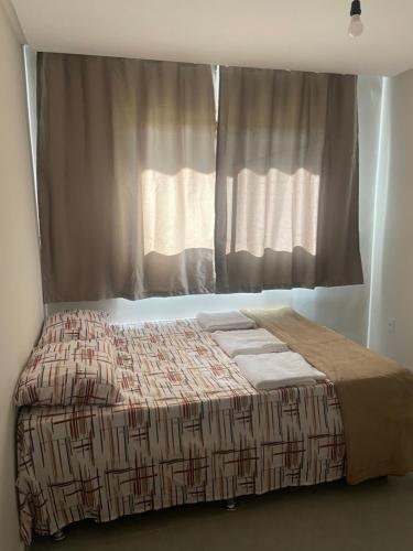 a bed in a room with a window at Brisa Suave Serra in Bezerros