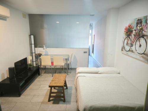 a room with two beds and a table with a bike on the wall at Olof Apartment in Las Palmas de Gran Canaria