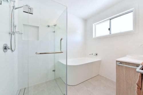 a bathroom with a shower and a tub and a sink at Gidget's Getaway in Nelson Bay