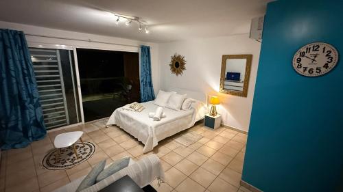 a bedroom with a bed and a clock on the wall at BLUE LAGOON - Terrace View & Beach Access - FREE WIFI PARKING - Bora Bora Dream - SPECIAL OFFER in Bora Bora