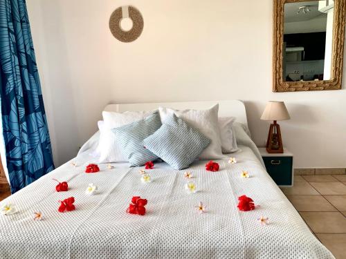a white bed with red flowers on it at BLUE LAGOON - Terrace View & Beach Access - FREE WIFI PARKING - Bora Bora Dream - SPECIAL OFFER in Bora Bora