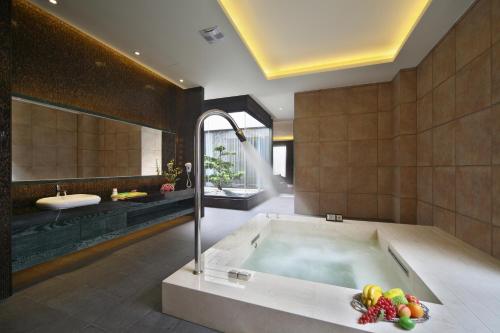 a bathroom with a tub with a bowl of fruit in it at Han Guan Motel in Taichung