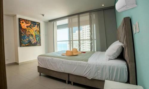 a bedroom with a bed with a hat on it at Lindo Apartamento en rodadero sur in Gaira