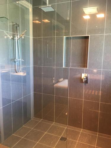 a bathroom with a shower with a glass door at The Glen in Raleigh