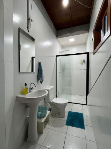 a bathroom with a toilet and a sink and a shower at Suite Familia B2 in Pomerode