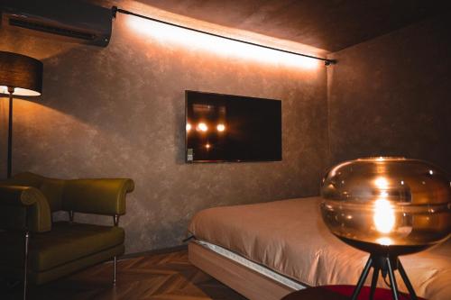 a bedroom with a bed and a chair and a television at Colline Dalat in Da Lat