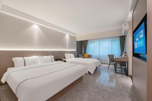 海口市にあるVeroia Hotel 维罗亚酒店のベッド2台と薄型テレビ付きのホテルの部屋