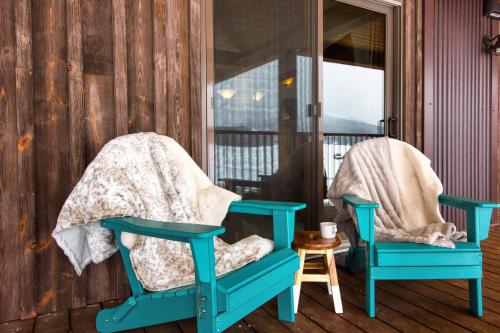 two blue chairs sitting on a porch at Highest Condo in CB with Stunning Views from Porch in Crested Butte