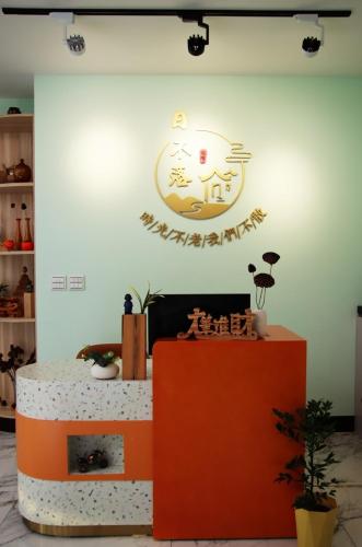 a room with a sign on the wall and a table at The sun never sets B&B in Budai