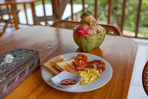 een bord roerei en toast op een tafel bij Mahendra Cottage in Nusa Penida
