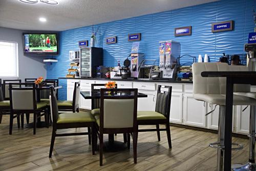 a restaurant with tables and chairs and a blue wall at Express Inn Parsons in Parsons