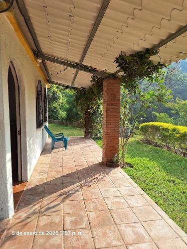 a patio with a blue bench under a roof at Pacaya House, Accommodation near Pacaya Volcano in San Vicente Pacaya