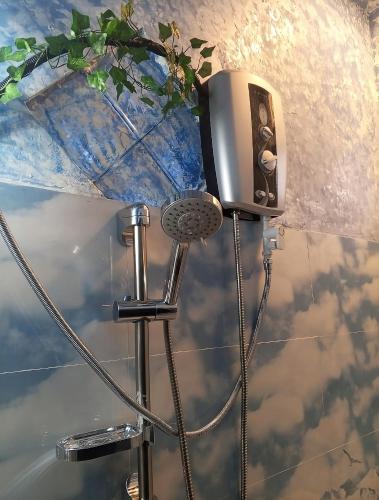 a shower in a bathroom with a mirror and a shower at Off grid Ella Homestay in Ella