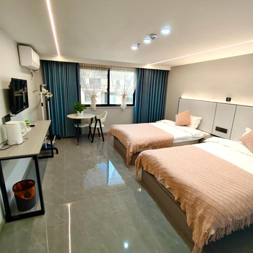 a hotel room with two beds and a table at Wangxian Valley Qingchuanxingguan - Wangxian Valley Scenic Area in Jiangcun