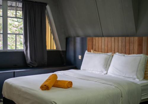 a bedroom with a bed with two yellow towels on it at Kavy Boutique Hotel @ KBH in Brinchang
