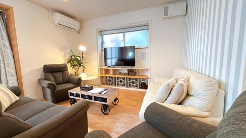 a living room with a couch and a tv at Condominium Palace Resort Chatan III in Chatan