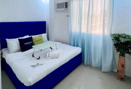 a blue bed with a tray on top of it at UrbanView at Balzain East Tuguegarao City by RedDoorz in Tuguegarao City