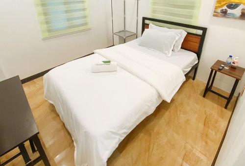 a white bed with a box on top of it at UrbanView at Balzain East Tuguegarao City by RedDoorz in Tuguegarao City