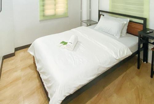a bed with a book and a remote control on it at UrbanView at Balzain East Tuguegarao City by RedDoorz in Tuguegarao City