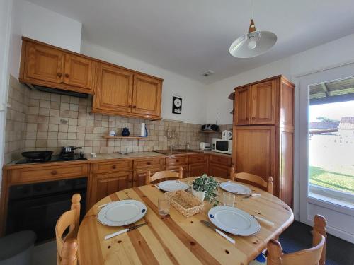 une cuisine avec une table en bois et des plaques de cuisson. dans l'établissement Maison à 500m de la plage avec jardin, terrasses et parking à Saint-Brevin-les-Pins - FR-1-364-50, à Saint-Brévin-les-Pins