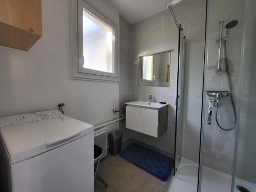 une salle de bain blanche avec une douche et un lavabo dans l'établissement Maison à 500m de la plage avec jardin, terrasses et parking à Saint-Brevin-les-Pins - FR-1-364-50, à Saint-Brévin-les-Pins