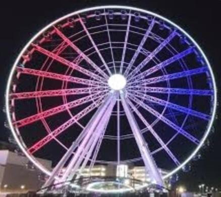 a large ferris wheel is lit up at night at Hackberry Hideaway in Frisco