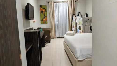 a hotel room with a bed and a tv at Summer Hills Hotel & Villas Bandung in Bandung