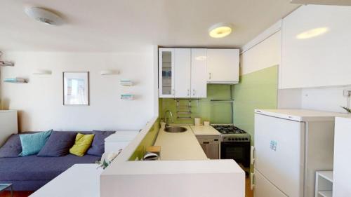 eine Küche mit einem Sofa und eine Küche mit einem Herd in der Unterkunft Studio in Centro "Stile Varsavia" con Check-in Automatico H24 in Casale Monferrato