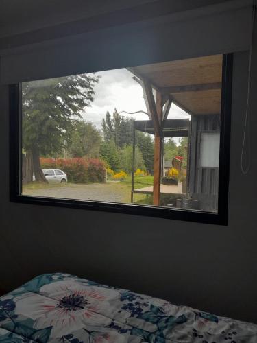 a mirror in a bedroom with a view of a yard at Pueblo Patagonia in Villa La Angostura