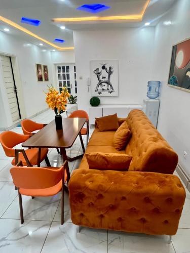 a living room with a brown couch and a table at Résidence Turpin in Toubab Dialaw