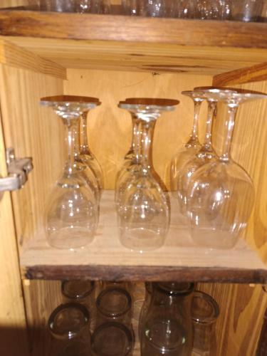 four clear glass vases sitting on a wooden shelf at Morena`s Home in Don Torcuato