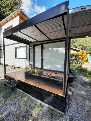 a tiny house with a deck and a large window at Pueblo Patagonia in Villa La Angostura