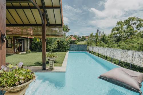 een zwembad in de achtertuin van een huis bij Tropical Villa Asmara - 400sqm Garden Oasis with large Pool and Scenic Views in Uluwatu