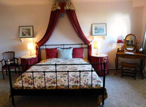 a bedroom with a canopy bed with two tables and two lamps at Das Bärenhaus in Bergen